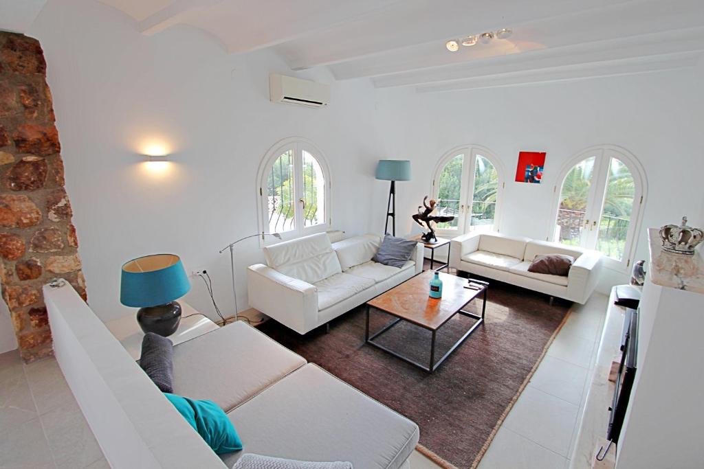 Living room with arched windows and exposed stone details at Moraira villa
