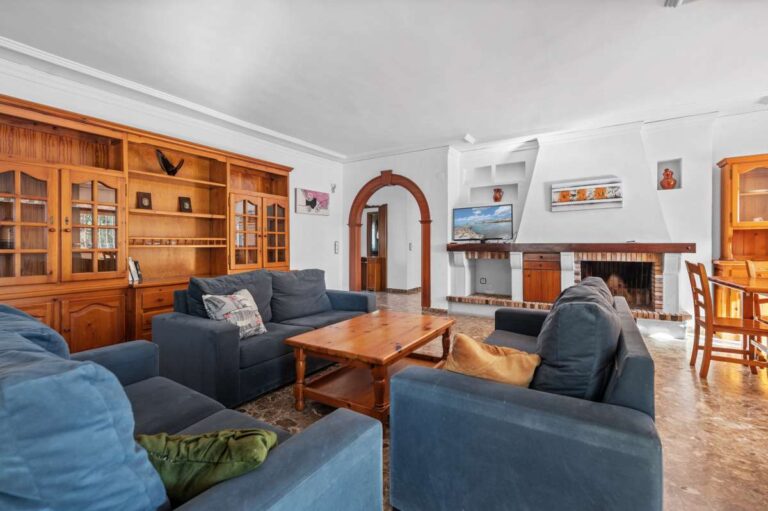 Living room with sofa seating, fireplace and natural light inside a spacious villa in Calpe.