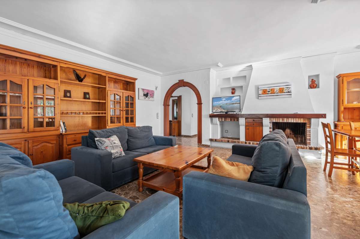 Living room with sofa seating, fireplace and natural light inside a spacious villa in Calpe.