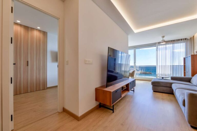 Lounge area inside a luxury frontline beach duplex in Mascarat, Altea with bedroom access, fitted storage, sea views and modern interior finish