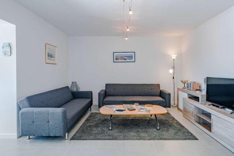 Lounge area inside a modern Calpe villa with sofa seating, TV unit and natural light