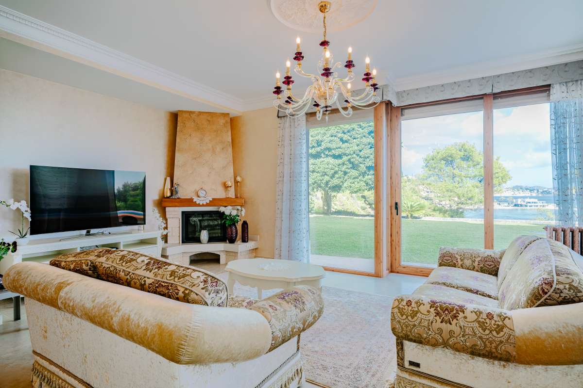 Lounge area with large windows, sea views and natural light inside a frontline villa in Les Bassetes, Benissa Coast.