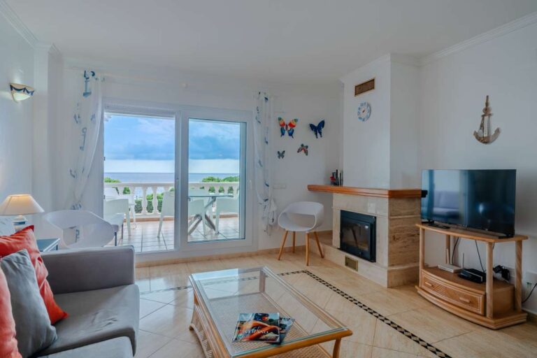 Lounge inside a duplex apartment near Les Platgetes Beach in Moraira with fireplace, TV area, terrace access and Mediterranean Sea views