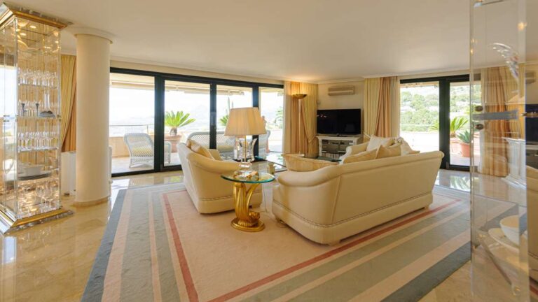 Lounge inside a luxury apartment in Sierra de Altea with sofa seating, marble flooring, large windows and direct access to the wraparound terrace