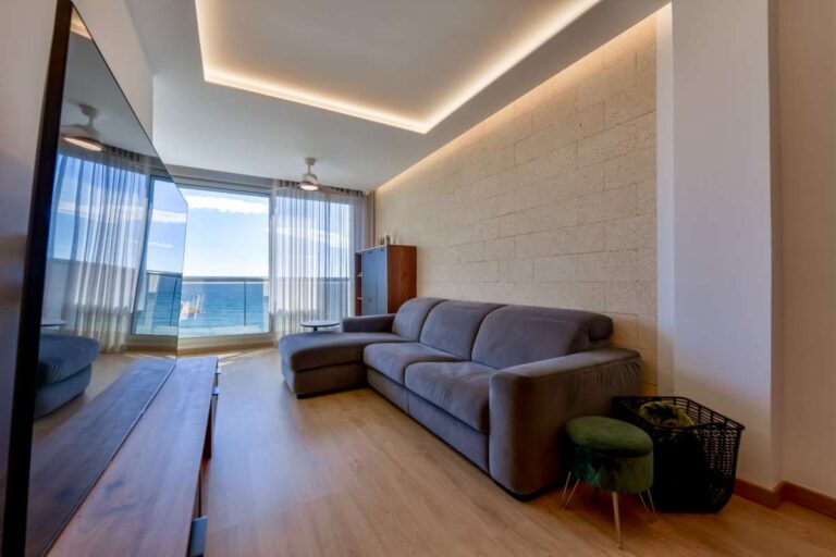 Lounge inside a luxury frontline beach duplex in Mascarat, Altea with sofa seating, terrace views, modern lighting and open sea views