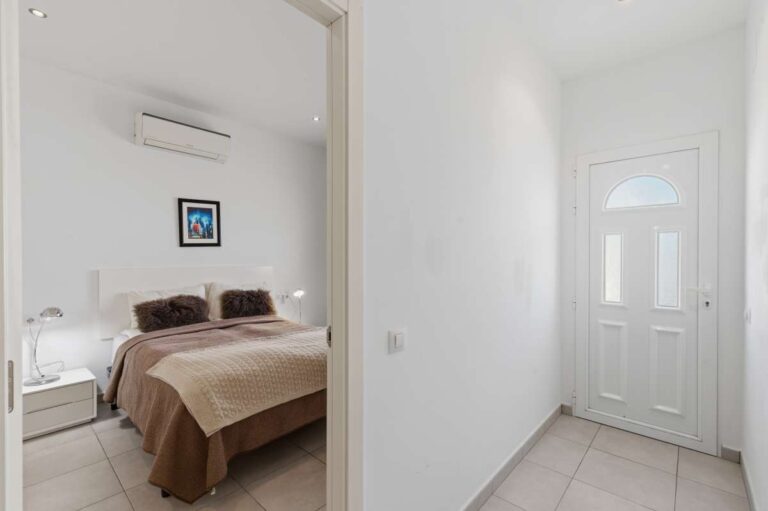 Lower-level bedroom with air conditioning and natural light inside a villa in Calpe.