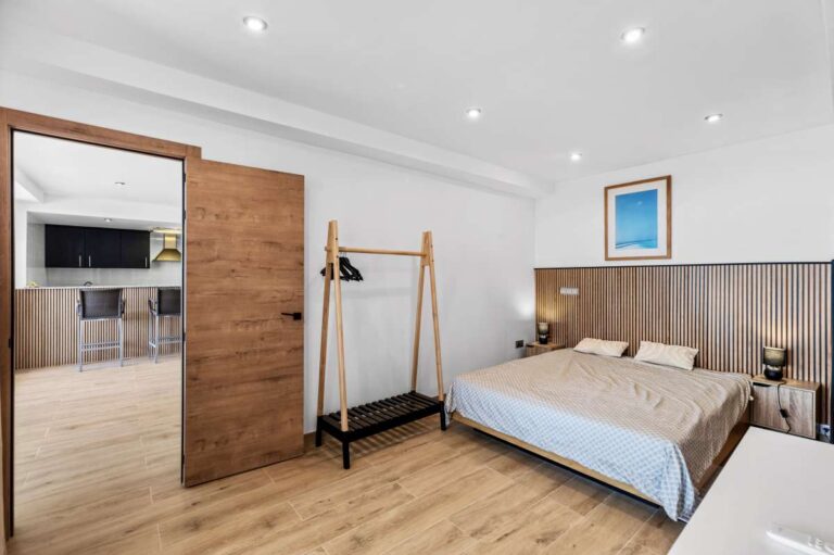 Lower level bedroom with natural light and wooden flooring inside a modern spacious villa in Calpe.