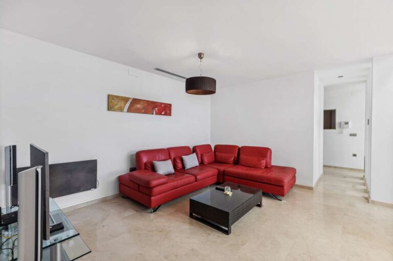 Lower level living area with red sofa inside a modern spacious villa with panoramic sea views in Calpe.