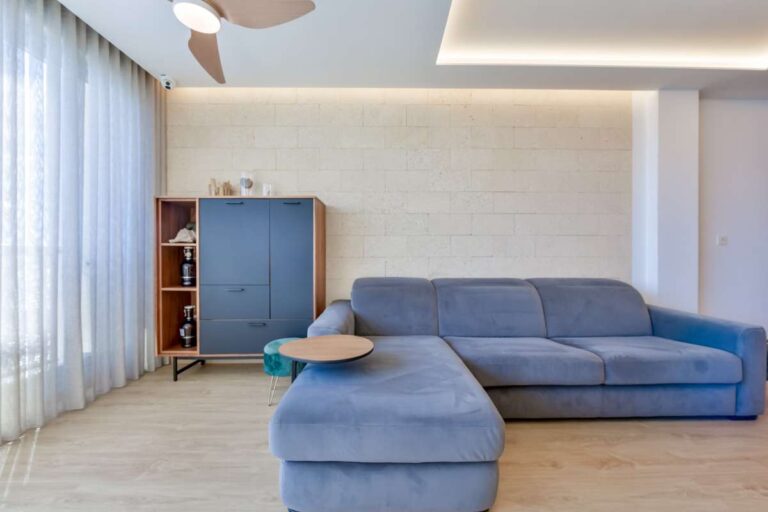 Lower-level living room inside a luxury frontline beach duplex in Mascarat, Altea with sofa seating, natural light and modern interior finish