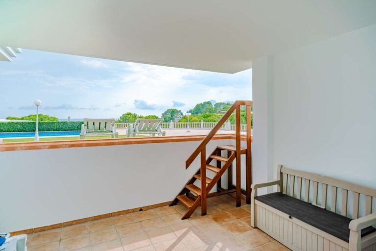 Lower terrace at a duplex apartment near Les Platgetes Beach in Moraira with exterior stairs, covered outdoor space and communal garden views