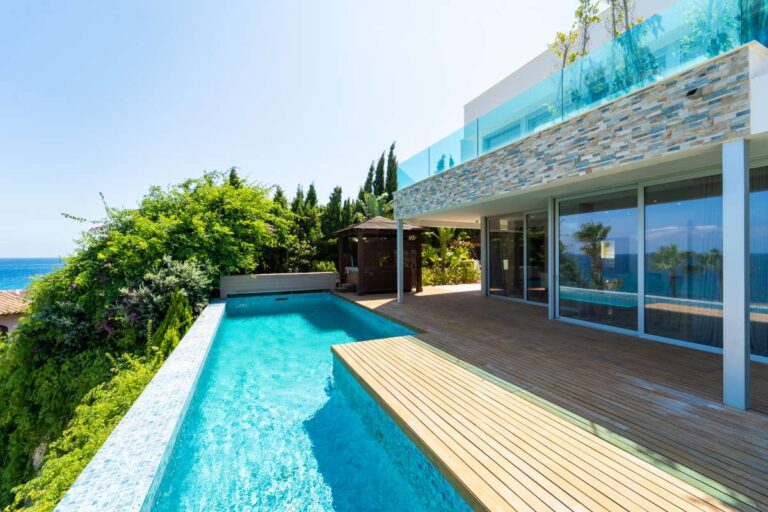 Luxury villa in Calpe with infinity pool, wooden decking, stone exterior details and panoramic Mediterranean Sea views