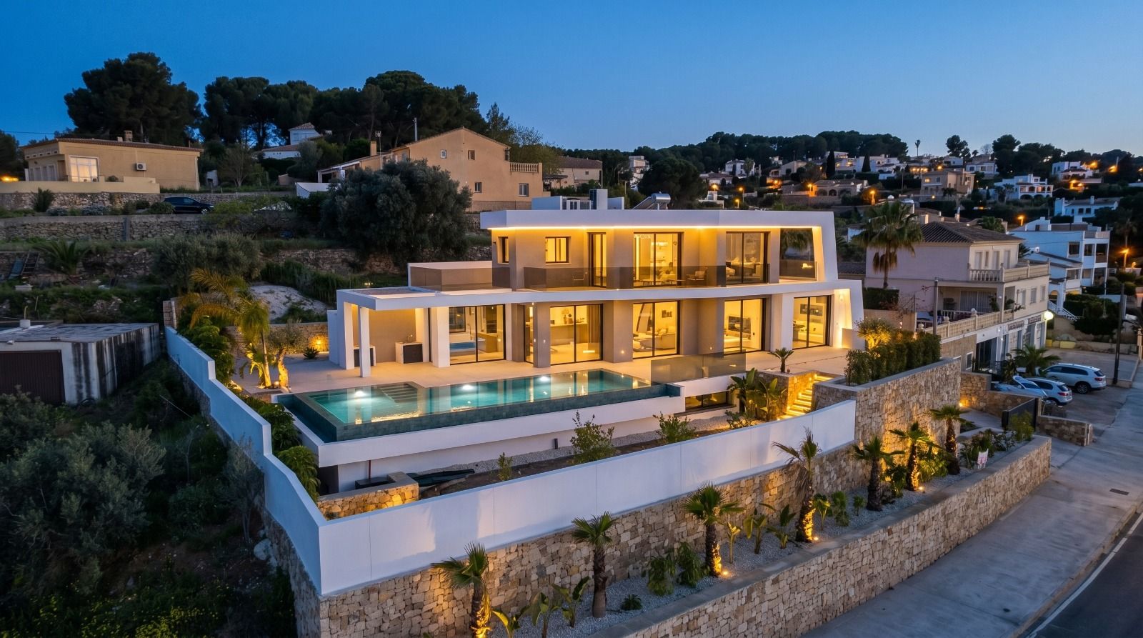 Luxury villa near La Fustera Beach illuminated at dusk with sea views