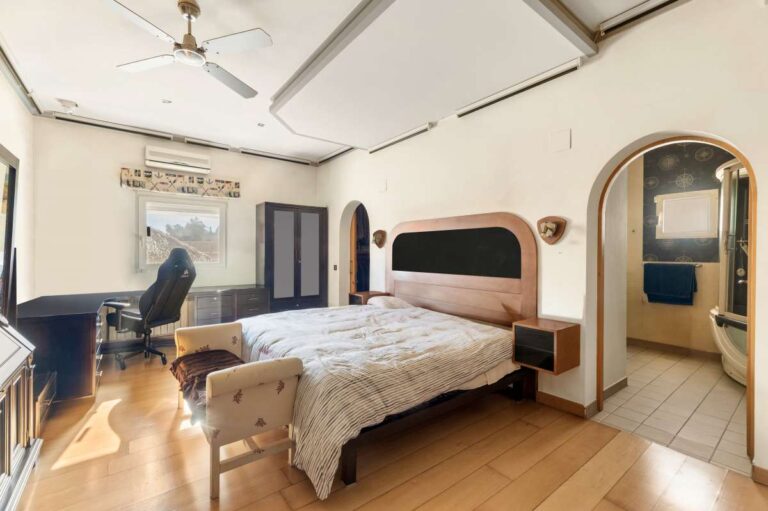 Main bedroom inside a private villa in Calpe with large bed, seating area, dressing space and natural light