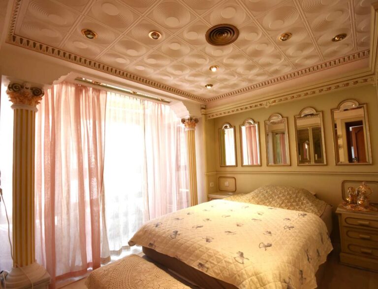 Main bedroom with decorative ceiling, custom-made furniture and natural light inside a frontline double penthouse in Calpe.