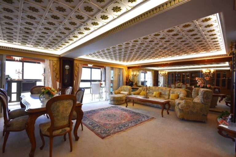 Main living room with custom-made furniture, decorative ceiling and large windows inside a frontline double penthouse on Arenal Beach in Calpe.