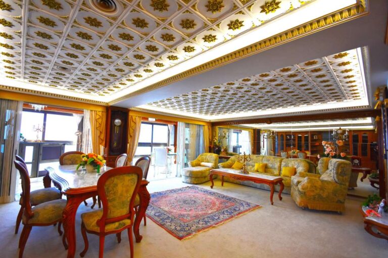 Main living room with custom-made furniture, dining area and large windows inside a frontline double penthouse on Arenal Beach in Calpe.