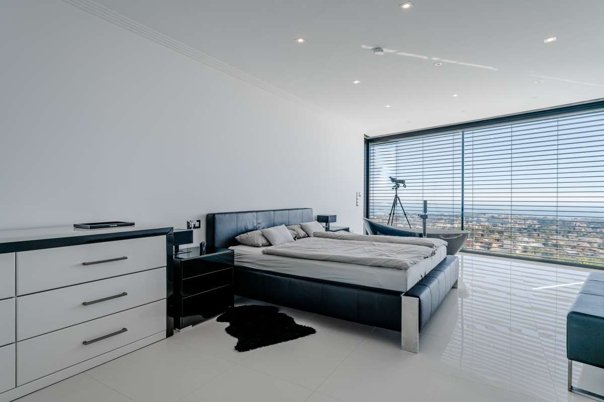 Main suite bedroom with contemporary finishes, fitted storage and panoramic sea views at a luxury villa in Gran Sol, Calpe.