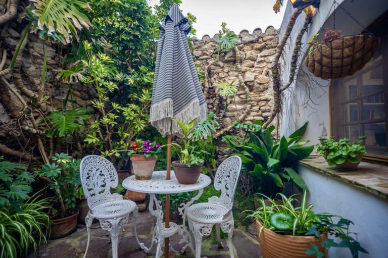 Mediterranean courtyard at a traditional Spanish finca near Moraira with outdoor table, potted plants, stone walls and shaded garden setting