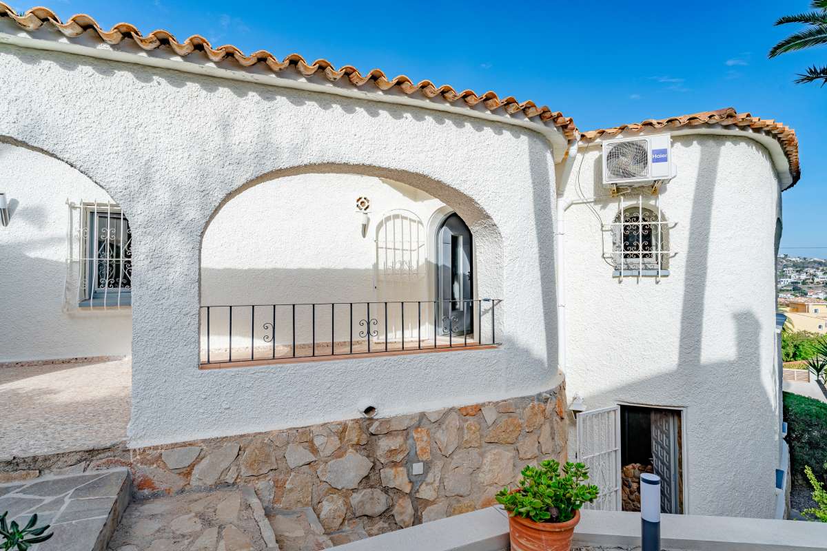 Mediterranean villa exterior with balcony, arched windows and traditional white façade in Maryvilla, Calpe.