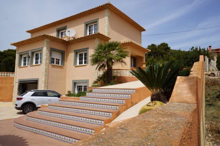 Mediterranean villa exterior with entrance steps, driveway and garden area near La Calalga Beach in Calpe.