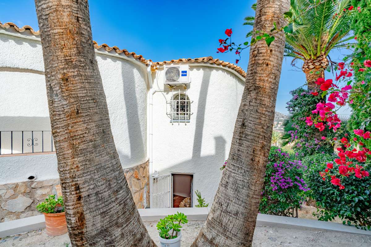 Mediterranean villa exterior with palm trees and traditional white façade in Maryvilla, Calpe.