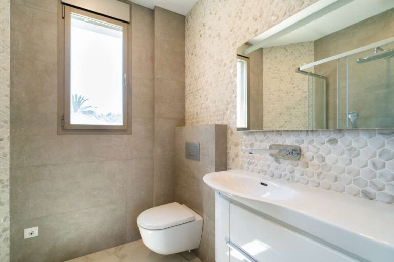 Modernes Badezimmer in einer neu gebauten Luxusvilla in der Nähe des Yachthafens Puerto Blanco in Calpe mit wandhängendem WC, großem Spiegel, Waschtisch und Fliesenboden