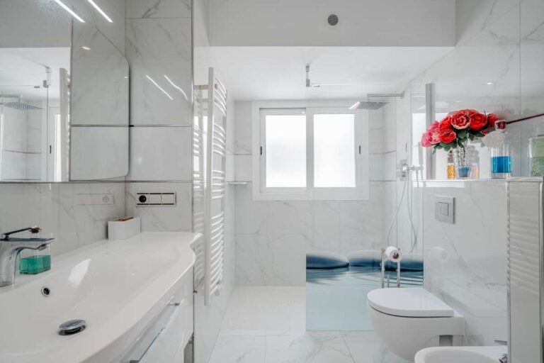Modern bathroom inside a renovated apartment by Arenal-Bol Beach in Calpe with bath, shower fitting, vanity unit and natural light