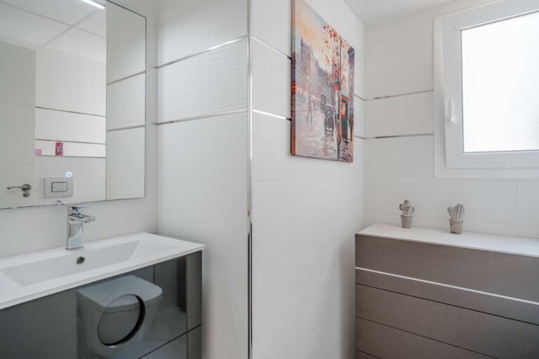 Modern bathroom inside a renovated apartment in Arenal-Bol, Calpe with vanity unit, window and bright white finish