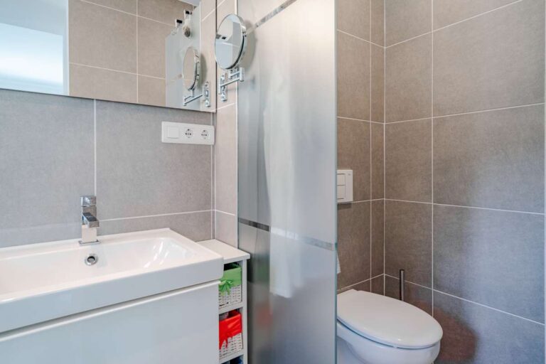 Modern bathroom inside a villa in Calpe with shower, vanity unit, toilet and tiled finish