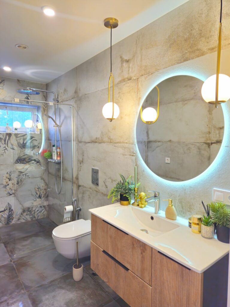 Modern bathroom inside a villa near Les Bassetes in Calpe with double vanity, round mirror, walk-in shower and contemporary finish