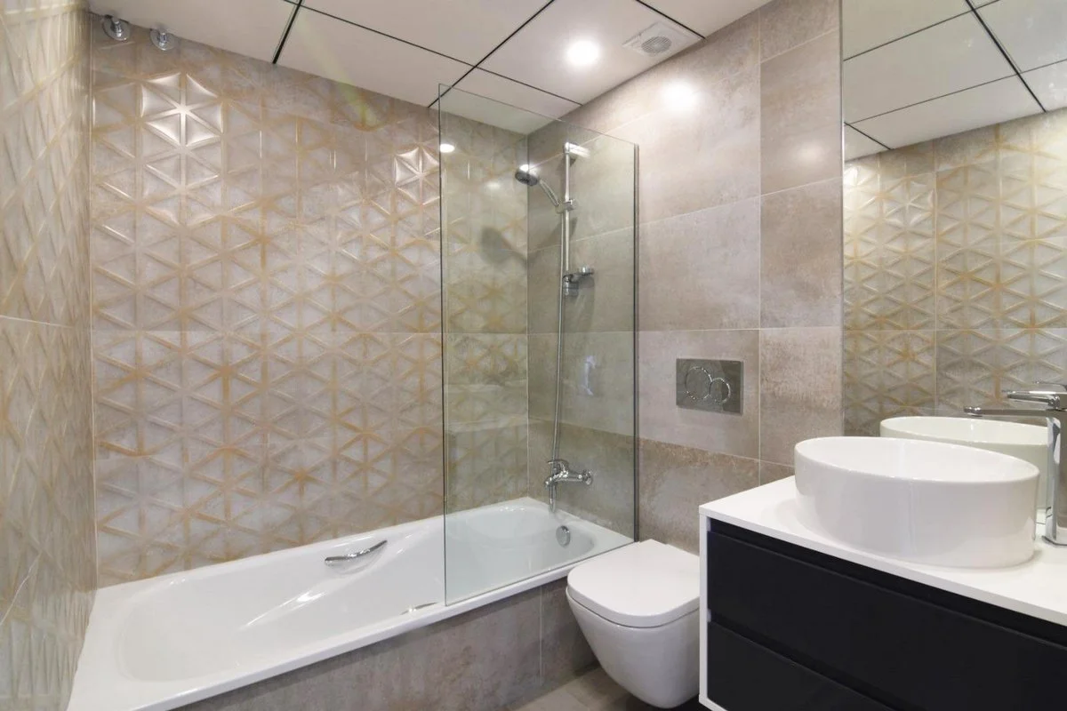 Modern bathroom with bathtub and glass shower screen in villa in Calpe