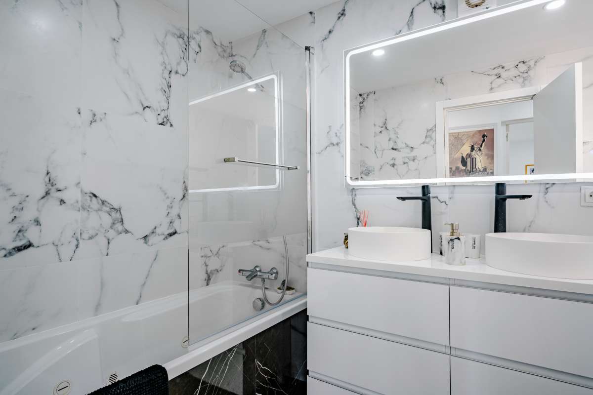 Modern bathroom with double vanity, bath and glass shower screen inside a renovated Mediterranean villa in La Cometa, Calpe.