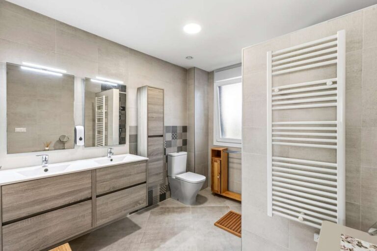 Modern bathroom with double vanity, towel radiator and walk-in shower inside a contemporary villa in Calpe.