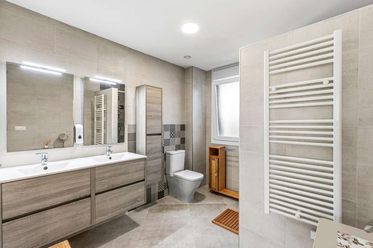 Modern bathroom with double vanity, towel radiator and walk-in shower inside a contemporary villa in Calpe.