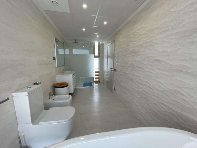 Modern en-suite bathroom inside a luxury villa in La Calalga, Calpe with bath, toilet, bidet and contemporary tiled finish