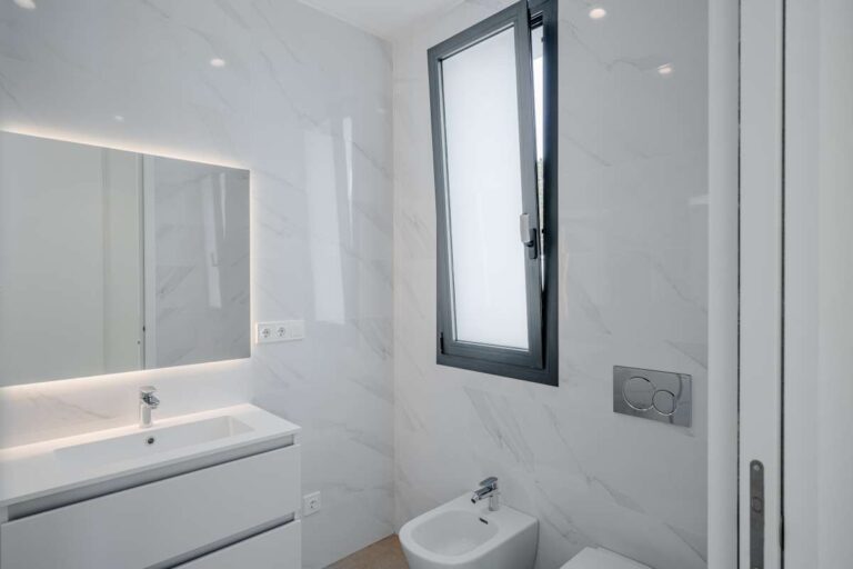 Modern en-suite bathroom inside a second-line sea villa in La Calalga, Calpe with vanity unit, window and bright contemporary finish