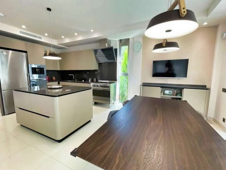 Modern kitchen inside a luxury villa in La Calalga, Calpe with central island, dining table, integrated appliances and contemporary lighting