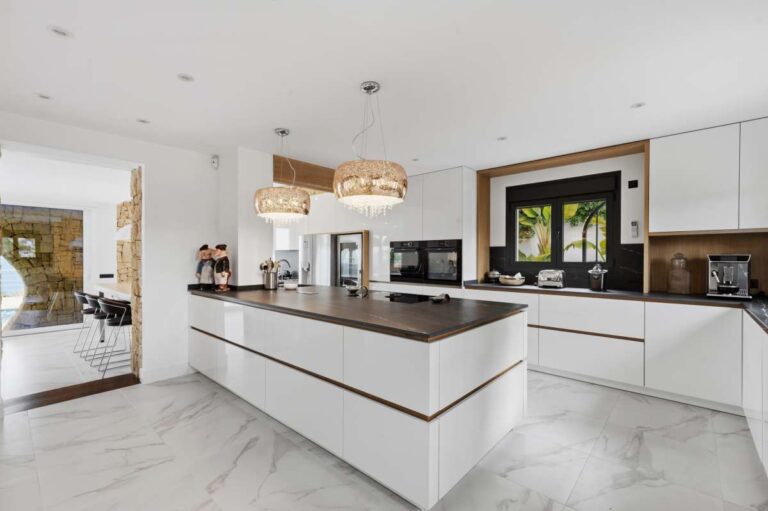 Modern kitchen inside a premium coastal villa on the Benissa Costa with central island, integrated appliances, white cabinetry and bright interior finish
