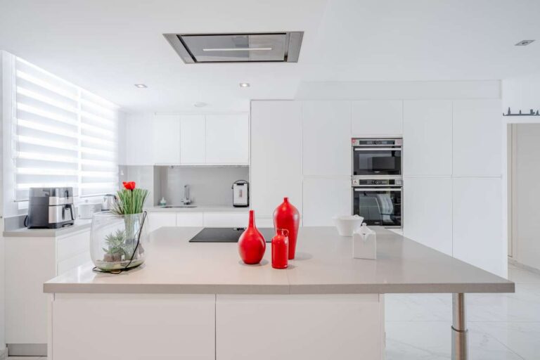 Modern kitchen inside a renovated apartment in Arenal-Bol, Calpe with island, integrated appliances and bright white finish