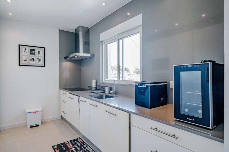 Modern kitchen inside a villa for sale in Calpe with white cabinets, appliances and natural light