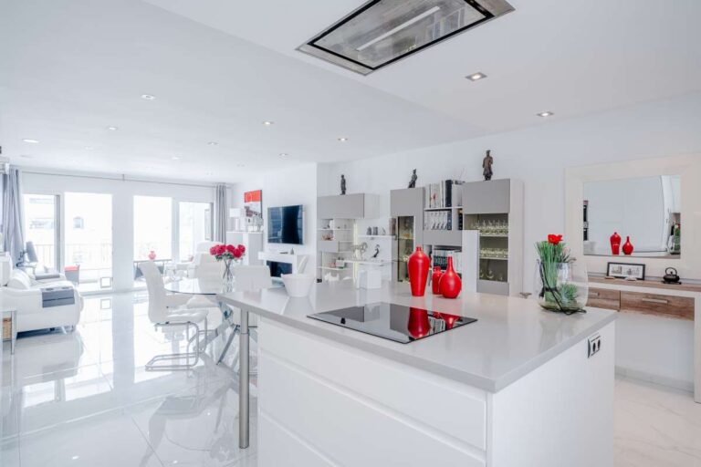 Modern kitchen island inside a renovated apartment by Arenal-Bol Beach in Calpe with open-plan living space and bright white finish