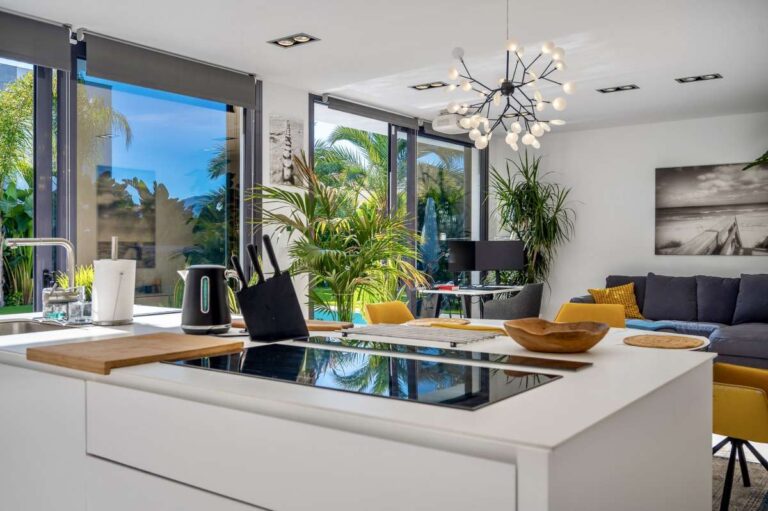 Modern kitchen island with garden views and open-plan living area inside a modern oasis villa in Calpe