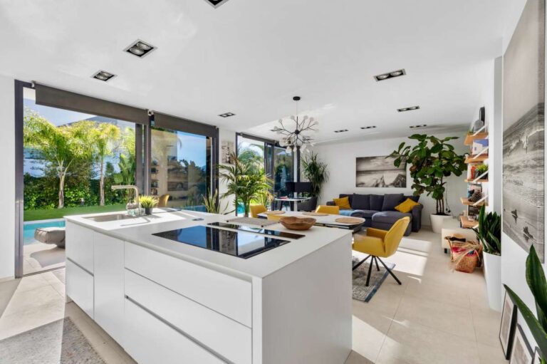 Modern kitchen island with open-plan living area and terrace access inside a modern oasis villa in Calpe.