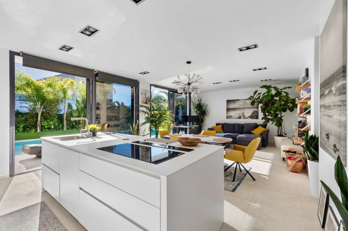 Modern kitchen island with open-plan living area and terrace access inside a modern oasis villa in Calpe.