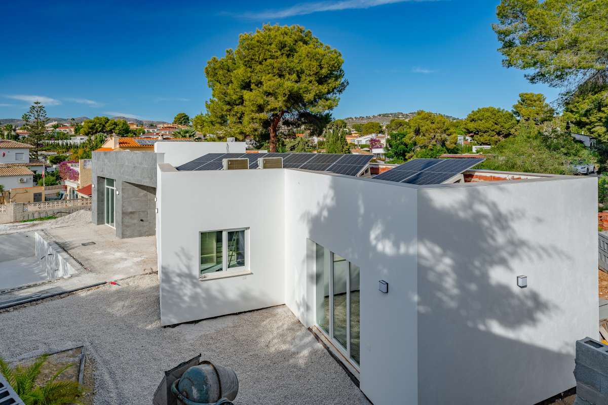 Modern new build villa exterior with private plot, surrounding trees and open views in Calpe