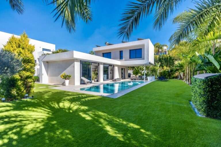 Modern oasis villa exterior with lawn, tropical garden and private pool area in Calpe.