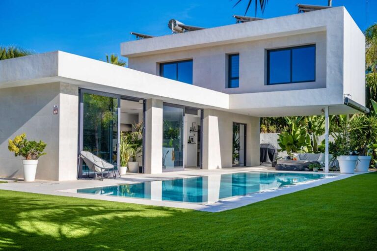Modern oasis villa in Calpe with infinity pool, lawn, terrace and contemporary white exterior.
