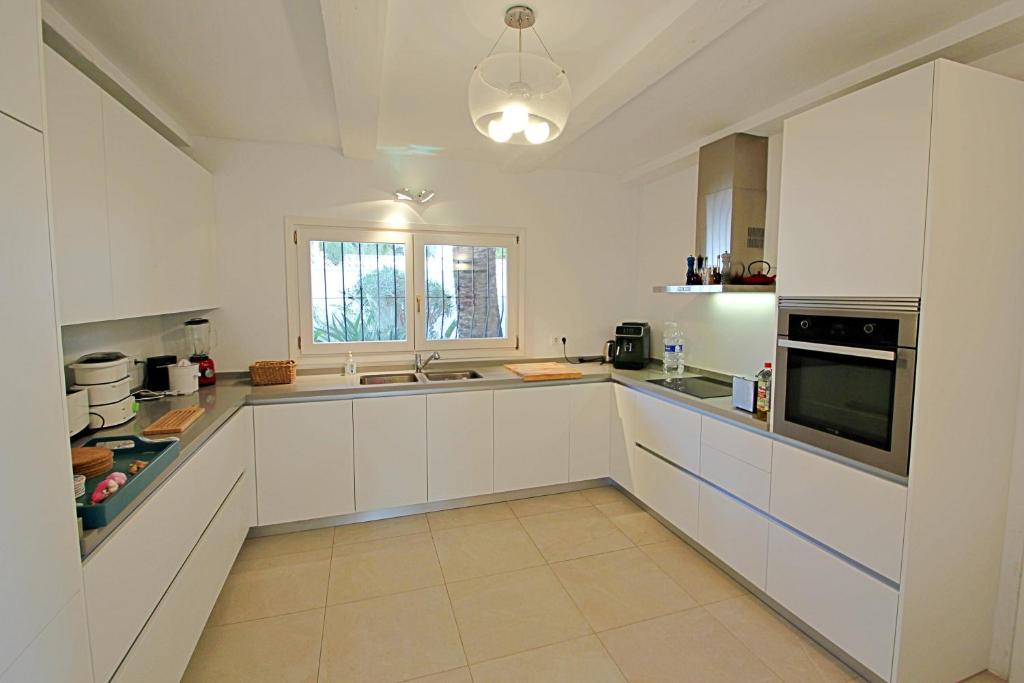Modern white kitchen with integrated appliances at south-facing villa in Moraira