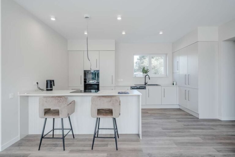 Modern white kitchen with island and breakfast bar inside a new build villa for sale in Calpe