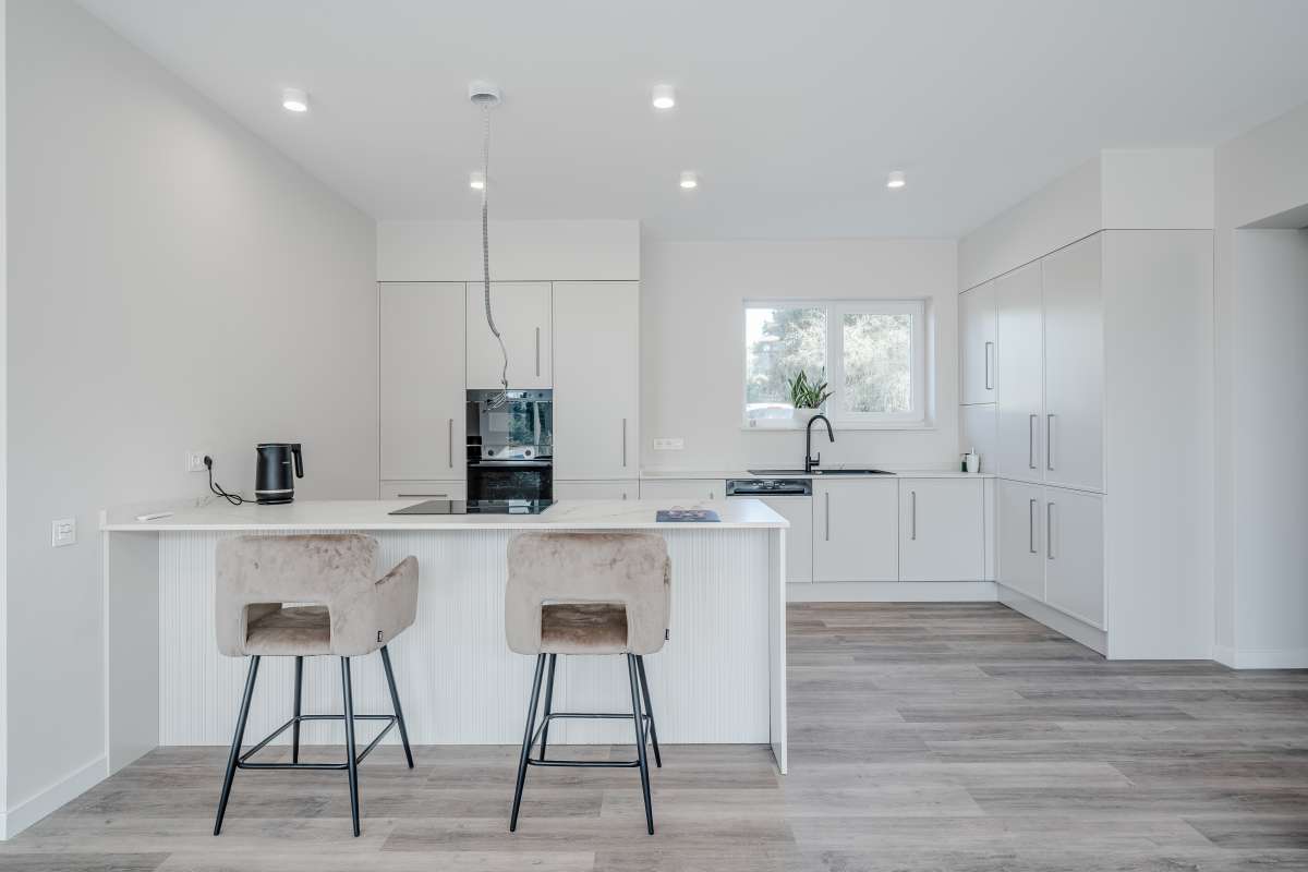 Modern white kitchen with island and breakfast bar inside a new build villa for sale in Calpe